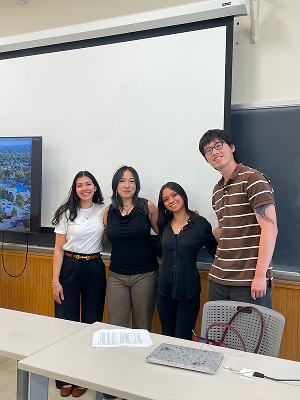 Capstone team in front of a presentation screen